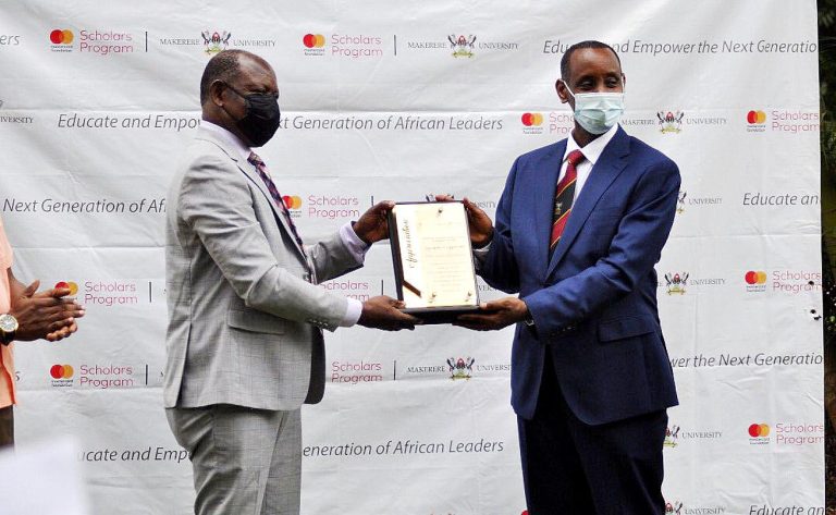 The Vice Chancellor, Prof. Barnabas Nawangwe (L) hands over a plaque to Assoc. Prof. Aaron Mushengyezi, Former member of the MCF Steering Committee and Chairperson, Selection Sub-Committee in recognition of his service on 19th December 2020 at the Makerere University Guest House.